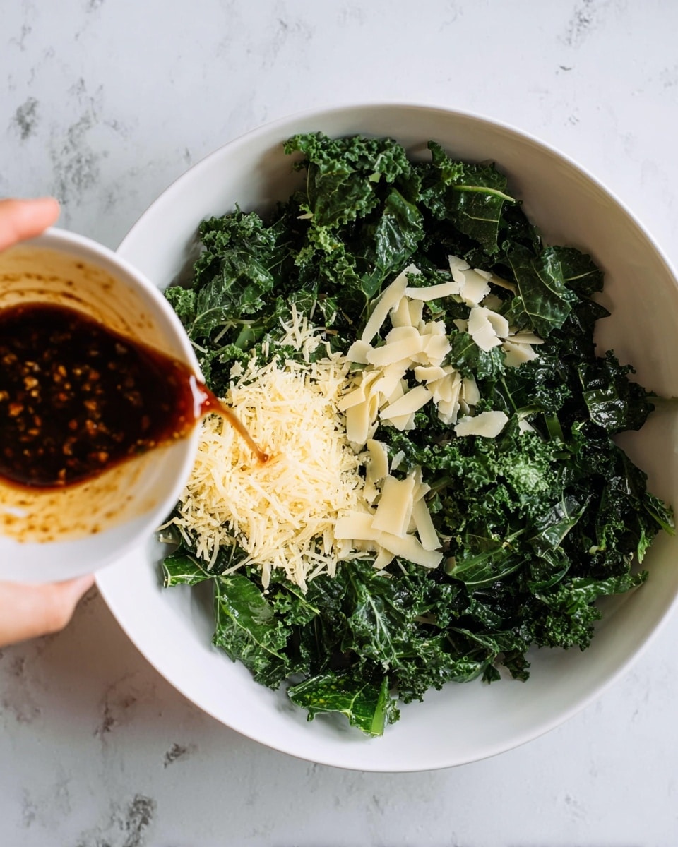 A large white bowl filled with dark green curly kale as the base layer, topped with a small pile of grated light yellow cheese on one side and scattered thin pale cheese flakes on top. A dark brown sauce with visible small bits is being poured into the bowl from the left side, held by a woman's hand. The bowl is set on a white marbled surface. Photo taken with an iphone --ar 4:5 --v 7