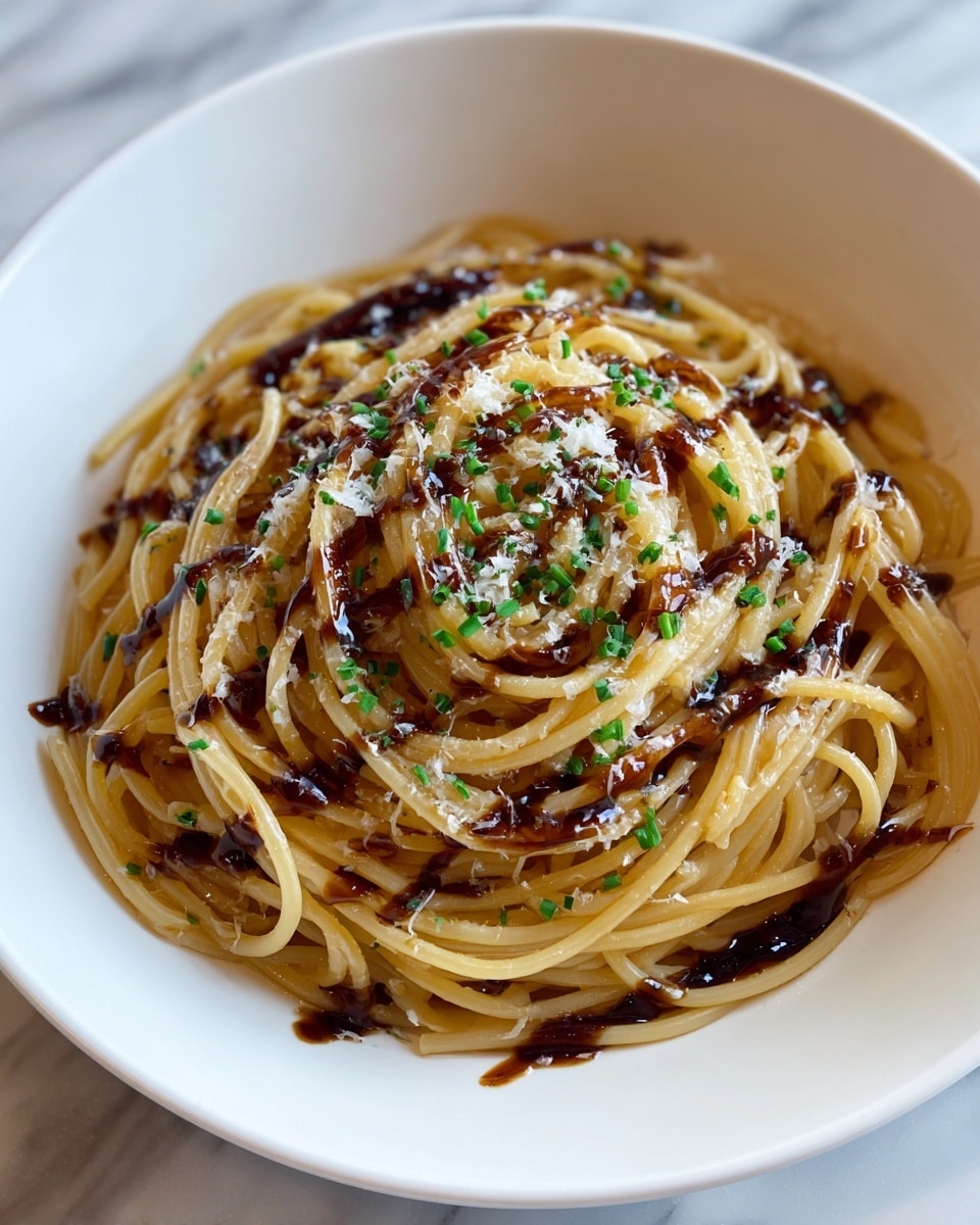 A white bowl holds a neat pile of light golden spaghetti noodles, arranged in a tight circle with some strands looping around the edges. The noodles are lightly coated with a glossy sauce that adds a slight shine. Dark brown sauce is drizzled over the top in wavy lines, adding contrast. Small green bits of chopped chives are scattered evenly across the noodles, along with tiny white sprinkles of grated cheese. The bowl sits on a white marbled surface. photo taken with an iphone --ar 4:5 --v 7