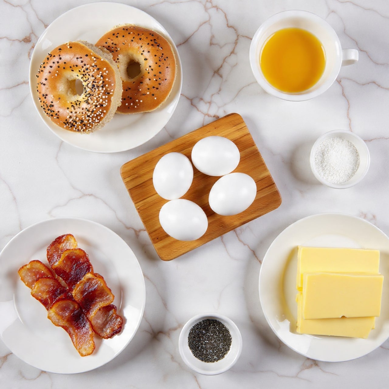 The image shows two toasted bagels with poppy and sesame seeds on top, placed on a white plate in the top left corner. To the right, there is a small bowl with a bright yellow egg yolk in the center. Below this, there are four whole white eggs arranged on a small wooden board. In the bottom left, crispy cooked bacon strips lie on a white plate along with a small bowl of coarse salt. In the center, a plate holds several slices of pale yellow butter. To the right of the butter, there is a stack of sliced yellow cheese on a white plate. Finally, in the bottom center, a small bowl contains ground black pepper. All items are set on a white marbled surface. Photo taken with an iphone --ar 4:5 --v 7