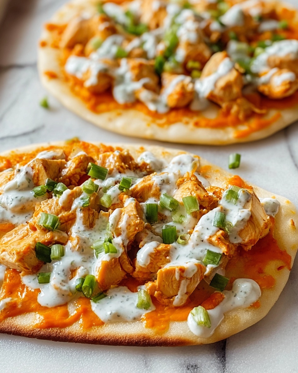 Two flatbreads on a white marbled surface each have three main layers. The base layer is a light golden flatbread with a soft, slightly puffy texture. The middle layer is an even spread of bright orange sauce with a smooth and glossy look. On top are chunky pieces of light beige cooked chicken scattered generously. The final layer is a drizzle of creamy white sauce with small green herb flecks, topped with small chopped green scallions for a fresh pop of color. The photo taken with an iphone --ar 4:5 --v 7