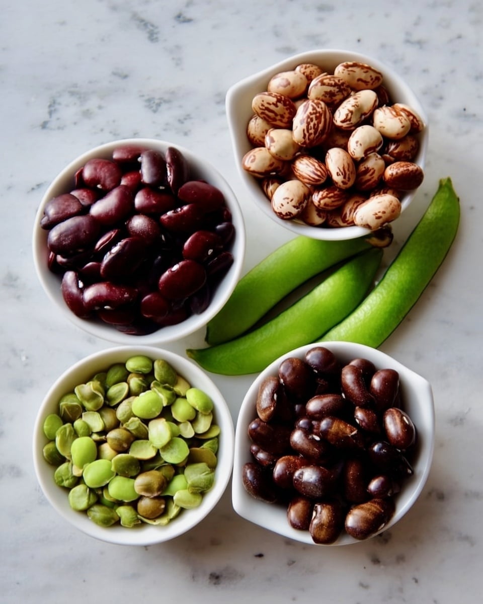 Four small white dishes are filled with different beans or seeds, placed closely on a white marbled surface. The top left dish holds shiny dark reddish-brown beans, while the top right dish contains light brown, slightly wrinkled beans. Below them, the bottom left dish is filled with bright green split seeds, and the bottom right dish has small, smooth, dark brown beans. To the right of the dishes, there are three long light green pods lying on the marbled surface. The scene is simple and colorful, showing the natural textures and colors of the beans and pods. photo taken with an iphone --ar 4:5 --v 7