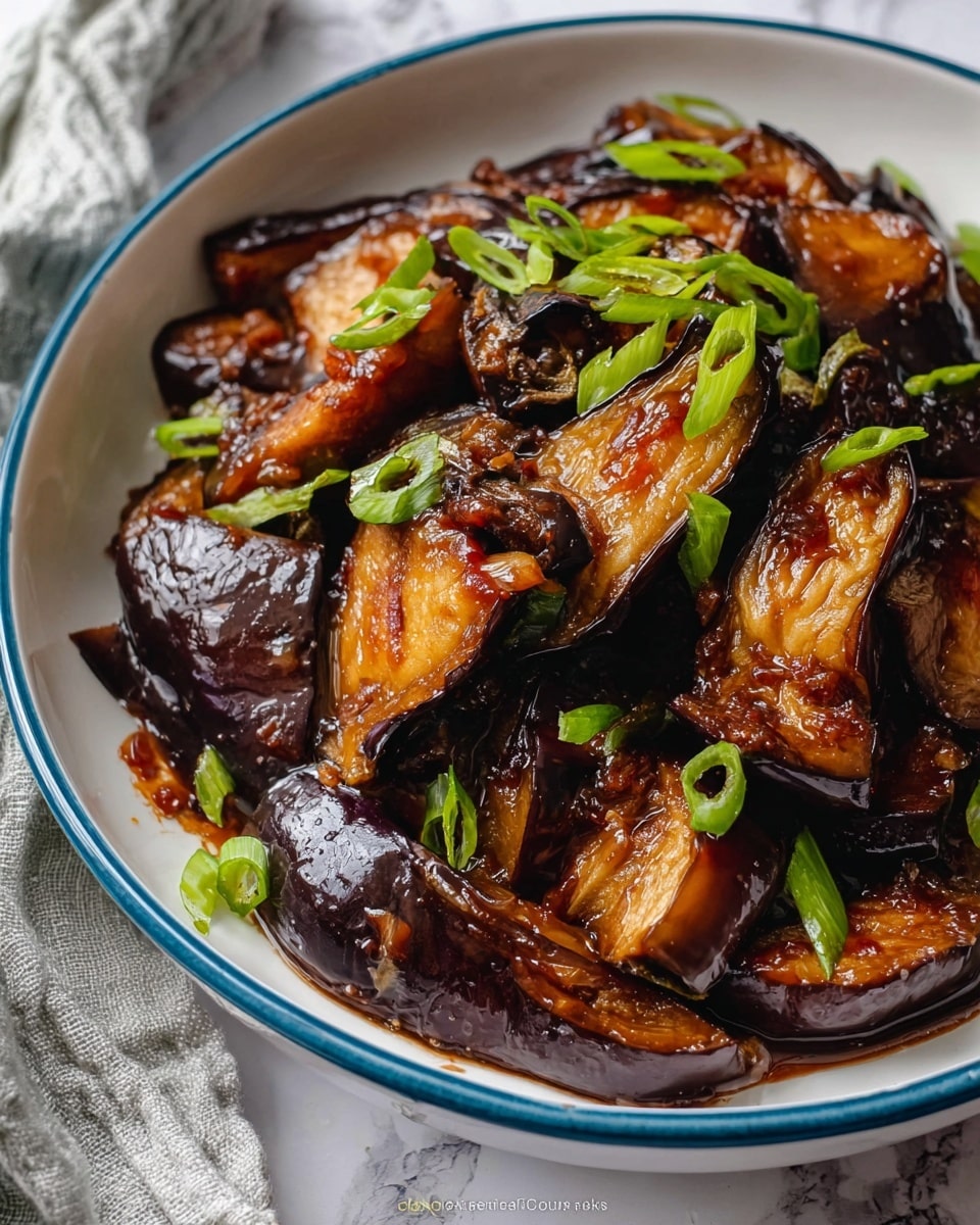 The image shows a white plate with a blue rim filled with cooked eggplant pieces, each piece browned and covered in a shiny, dark brown sauce. The eggplant slices are arranged randomly, with some pieces showing a soft, golden inside and others with a darker purple skin. Small green slices of scallion are scattered on top, adding a fresh touch. Surrounding the plate are two white bowls filled with white rice, and wooden chopsticks rest beside the bowls. The surface is a white marbled texture under the plate and bowls. photo taken with an iphone --ar 4:5 --v 7