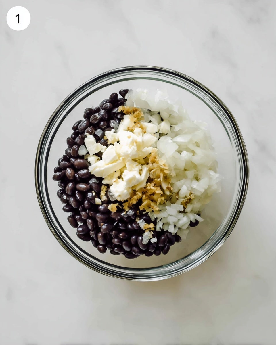 A clear glass bowl placed on a white marbled surface holds three main layers: the bottom layer is made of smooth, shiny black beans; above that is a layer of small, finely chopped white onions; and the top layer features slightly larger pieces of creamy white cheese with some golden bits scattered on top. photo taken with an iphone --ar 4:5 --v 7
