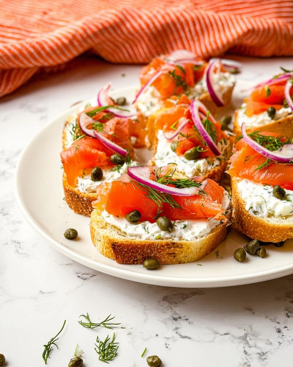 The image shows several pieces of toasted bread arranged in a white plate on a white marbled surface. Each piece has a thick layer of creamy white spread dotted with green herbs and small capers. On top of the spread, there are bright orange slices of smoked salmon, each topped with thin, curved strips of purple-red onion and sprinkled green dill. Some loose capers and finely chopped dill are scattered around the plate, adding texture and color. In the background, there is a soft-focus orange and red striped cloth. The scene is brightly lit, capturing the fresh and appetizing colors of the dish photo taken with an iphone --ar 4:5 --v 7